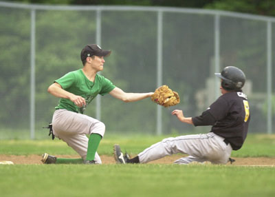 Celina's Cody Koesters tries to make a tag on a sliding Sidney runner during Thursday's game at Eastview Park. The Yellow Jackets defeated Celina 15-3.<br>dailystandard.com