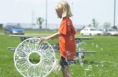 Olivia Winner of Minster swings a plastic disc leaving multiple bubbles at Four Seasons Park in Minster. Winner is one of dozens of local youngsters who participated in Bubblefest activities Monday afternoon.<br>dailystandard.com