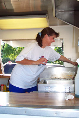 Mary Krohn cleans the bratwurst trailer she and her husband Mark have brought to the Auglaize County Fair. It takes six to eight hours to prepare the stand for opening day with nearly an hour needed each morning to prepare marinara sauce and cook a fragrant mixture of peppers and onions before the delicious aroma draws customers.<br>dailystandard.com