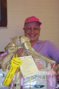 Vicky Dysert, an employee of Joint Township District Memorial Hospital in St. Marys, holds the basket accounting department employees put together in her honor. Dysert, who was diagnosed with breast cancer in May and is undergoing chemotherapy, hopes to submit the winning bid for the basket that includes handcrafted cards and other items arranged in a Christmas sleigh.<br>dailystandard.com