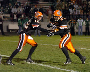 Coldwater's Steve Borger, left, hands off to Ross Homan, right, during their Division IV playoff game on Friday night. Homan had five touchdowns in the Cavaliers' 41-35 double overtime win over Delta.<br>dailystandard.com