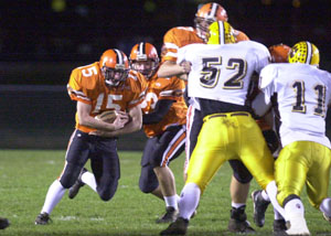 Versailles' Adam Francis, 15, follows his blockers on a run during Friday's playoff game. Francis ran for 76 yards and a touchdown in the Tigers' 28-0 win.<br>dailystandard.com
