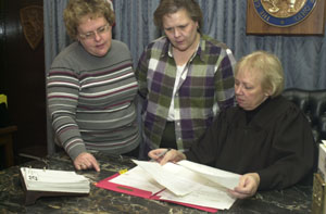 Mercer County Juvenile Court Judge Mary Pat Zitter reviews the file of a youth involved in the Delinquency Diversion Program for first-time offenders. Looking on are grant administrator Sue Wilkins, at left, and diversion officer Colleen Bigham. The program works with non-violent offenders away from the traditional courtroom setting.<br>dailystandard.com