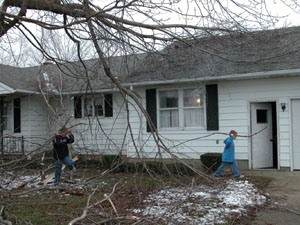 Tony Beyke, 13, left, and his brother, Shawn, 10, help pick up limbs that fell around the family's home in Sebastian, near Chickasaw. A large tree branch fell across the roof of their home on County Road 716A but appears to have caused no damage. Others in the Grand Lake St. Marys area weren't as fortunate, as roof damage and broken windows are keeping area homeowners busy cleaning up from the wrath of last week's ice storm.<br>dailystandard.com