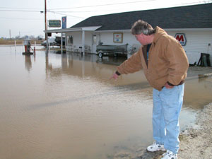 Chuck Black of Montezuma points to a submerged seawall near the Windy Point Marina following Tuesday's rainfall. Many communities are dealing with flooding as area rivers and creeks, as well as Grand Lake St. Marys, have overflowed in recent days.<br>dailystandard.com