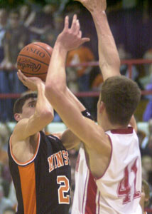 Minster's Andy Beckman, left, shoots over the outstretched arms of St. Henry's Kurt Huelsman, right, during their Midwest Athletic Conference matchup on Friday night. Beckman scored a game-high 21 points but St. Henry won the game, 63-58.<br>dailystandard.com