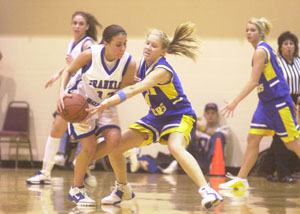 Marion Local's Holly Fortkamp, 4, reaches in for a steal on Franklin-Monroe's Mara Howell, with ball, during their Division IV regional semifinal on Thursday night at the Student Activity Center at Vandalia-Butler High School. Marion Local defeated Franklin-Monroe, 61-51.<br>dailystandard.com