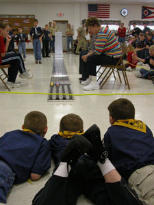 A group of boys from Cub Scout Pack 101 of St. Henry gathers near the finish line during the annual Pinewood Derby racing event on Sunday.<br>dailystandard.com