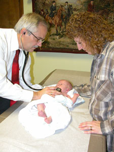 Dr. Jerry Sell of Rockford examines tiny Aaron David Hipply as his mother, Patty, stands nearby. Born March 16, Aaron was one of Sell's last deliveries following a growing tend by family physicians locally and around the country to quit the obstetrics portion of their practices due to the high cost of medical malpractice insurance.<br>dailystandard.com