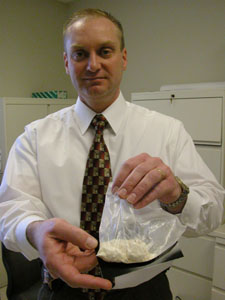 Auglaize County Sheriff's Detective Jerry Sawmiller displays one of several bags of powdered cocaine kept in the agencies' evidence room. Cocaine is considered the most significant drug threat in Ohio today and its use is increasing among drug abusers locally.<br>dailystandard.com