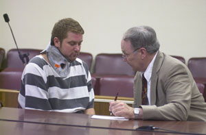 Wearing a neck brace due to three fractured vertebra, Columbus resident Ricky Driskill talks with defense attorney John Poppe during a Wednesday afternoon arraignment in Celina Municipal Court. Driskill reportedly suffered the injury in one of two accidents that occurred prior to a May 1 confrontation with police officers.<br>dailystandard.com