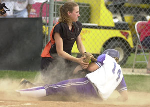 Fort Recovery's Krystal Rammel, 14, is called out at home plate as Minster's Leslie Muhlenkamp, top, makes the tag during Wednesday's Division IV sectional finals contest at New Bremen. Fort Recovery went on to win 3-2 behind a 3-for-3 day at the plate by Rammel.<br>dailystandard.com