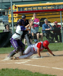 New Bremen's Morgan Cox, right, slides safely into home plate as Fort Recovery catcher Brenda Rindler, left, reaches for the ball.<br>dailystandard.com