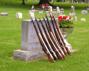 Rifles stand side by side on a tomb stone in Elm Grove Cemetery in St. Marys on Monday morning. Members of the Veterans of Foreign Wars Post 9289 provided the color guard and firing quad for the Memorial Day ceremonies. The seven-member team members each fired three times, making the full 21-gun salute.<br>dailystandard.com