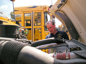 Dan Grothaus, transportation supervisor for St. Marys City Schools, checks out one of the district's 39 buses, which will be running on biodiesel fuel next school year. St. Marys will be the only area school to go with the renewable fuel, according to Grothaus.<br>dailystandard.com