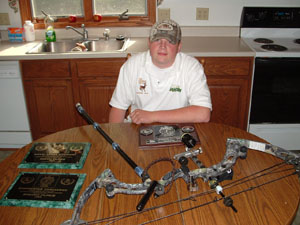 St. Henry's Brandon Jarrett poses with plaques won this season and his bow. Jarrett placed sixth at the International Bowhunting Organization's World Championships held last week.<br>dailystandard.com