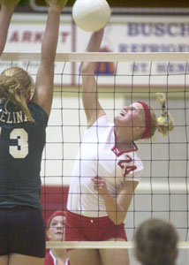 St. Henry's Bethany Puthoff, 24, hits the ball past Celina's Liz Homan, left, during their match on Tuesday night in St. Henry. Puthoff registered 12 kills in helping lead the Redskins past the Bulldogs in four games.<br>dailystandard.com