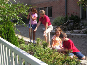 The land lab behind Celina Intermediate School is at its seasonal peak right now and members of the public are always welcome to visit. Carol Hone, a sixth-grade teacher, and students Lizy Adkins, left, Andrea Bell and Justin Hoffman enjoy a few minutes outside admiring the plant life.<br>dailystandard.com