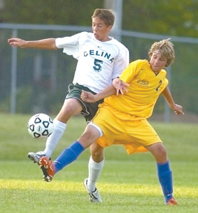 Celina's Neil Hoyng, 5, battles with St. Marys' Zac Hagan, right, during their match on Thursday night. Hoyng scored one of the Bulldogs' four goals in the 4-2 victory over the Roughriders.<br>dailystandard.com