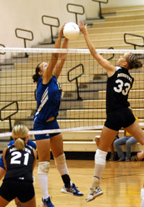 Minster's Erica Davis, 33, and St. Marys' Brittnay Roth, 12, battle at the net for a point during their match on Tuesday night. Minster defeated St. Marys in four games.<br>dailystandard.com