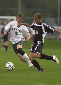 Celina's Chris Post, 4, tries to maneuver around Elida's Matt Stump, right, during their Western Buckeye League matchup on Thursday night. Post scored the tying goal in Celina's 1-1 tie against Elida.<br></br>dailystandard.com