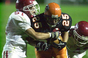 Coldwater's Ross Homan, 25, runs through a pair of St. Henry tackles during a run on Friday night  at Cavalier Stadium. Coldwater went on to defeat St. Henry, 31-7.<br></br>dailystandard.com