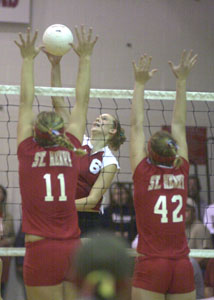 New Knoxville's Nicole Wright, 6, tries to hit the ball past St. Henry's blocking combo of Betsy Hoying, 11, and Brittany Post, 42, during their match on Thursday night. New Knoxville defeated St. Henry in five games.<br></br>dailystandard.com