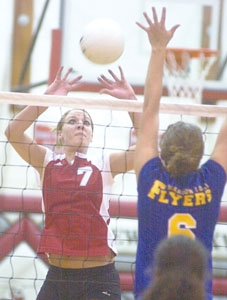 New Knoxville's Alycia Niemeyer, 7, sets the ball over the net as Marion's Stephanie Brunswick, 6, goes up to block.<br></br>dailystandard.com