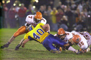 Coldwater's defensive trio of Trevor Stromblad, 7, Ryan Geier, 5, and Cody Muhlenkamp, 55, combine to make a tackle on St John's ball carrier Pat Kundert. Coldwater won the game, 35-21.<br></br>dailystandard.com