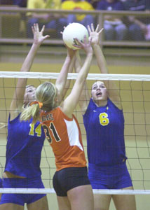 Marion Local's Stephanie Brunswick, 6, and teammate Jenna Barhorst, 14, combine to make the block on Jackson Center's Catie Halberstadt, 31, during their match on Thursday night.<br></br>dailystandard.com
