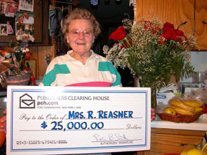 Celina resident Eileen Reasner, 83, poses with the $25,000 publicity check she received from the Prize Patrol of Publishers Clearing House, who showed up on her doorstep Thursday afternoon. Reasner, who works part-time cleaning homes, plans to pay off her debts with her early Christmas present.<br></br>dailystandard.com