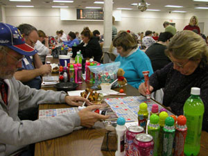 Celina residents Jim and Linda Moyers, in the foreground, and relatives Chuck and Velma Moyers clutter their table with a variety of good luck trinkets (pictures of their pets, coffee mugs and a cow bell) and plenty of colorful daubers for a night of bingo action.<br></br>dailystandard.com