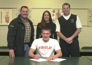Celina's Erik Chapin, seated, signs his national letter-of-intent to continue his football career at Findlay next year. Standing behind Chapin, from left, are parents Stan and Rhonda Chapin along with Celina head football coach Mike Fell.<br></br>dailystandard.com