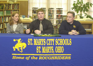 St. Marys standout running back Bo Frye, middle, signs his national letter-of-intent with Northern Michigan to continue his football career next fall. Seated beside Bo are his parents Kristi, left, and Doug Frye.<br></br>dailystandard.com