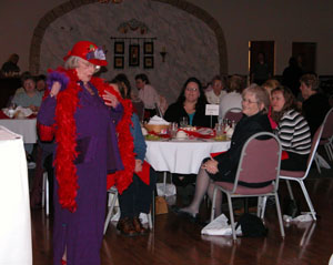Pat Giesige of the Ladies of the Red Hats of Celina gives a humorous performance as she models for the crowd at the Ladies Heart Health Gala in Celina on Tuesday. The event, which included health-related booths, a buffet meal and speakers, was sponsored by Mercer Health.<br></br>dailystandard.com