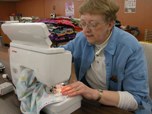 Linda Huston of Linda's Sew 'N So in Celina sews a label on a blanket to be donated to Project Linus, a program that distributes blankets to children of all ages who are in need of comfort. Feb. 18 is the 7th Annual Make a Blanket Day 2006, and volunteers can come to the business at 216 W. Fayette St. to help sew on the labels before the blankets are delivered.3<br></br>dailystandard.com