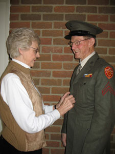Above, Martin Dabbelt when he served in the U.S. Marines during World War II. At left, New Bremen resident Martin Dabbelt smiles broadly as his wife, Rita, helps button the U.S. Marine Corps uniform he was issued six decades ago as a draftee.<br></br>dailystandard.com