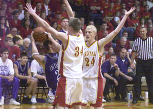 New Bremen's Scott Steineman, 34, and teammate Brian Schwartz, 24, trap Fort Recovery's Toby Metzger, with ball, during their Division IV sectional final contest at The Palace in Coldwater on Friday night. New Bremen escaped with a 45-36 victory over Fort Recovery to earn the first sectional title for the Cardinals since 1988.<br></br>dailystandard.com