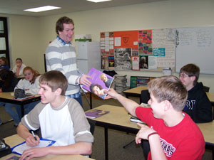 Miles Nugent, LifeSkills Training instructor, distributes a workbook to Keith Wenning at Coldwater Middle School health class. Eric Lefeld, Wenning and Patrick Forsthoefel are among students who learn from Nugent's personal experiences and workbook lessons. <br></br>dailystandard.com