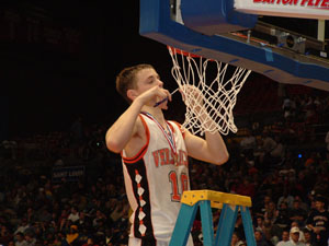 Versailles' Jeremy Shardo snips a piece of the net after the Tigers captured the Division III Dayton I District title with a 52-44 win over Jefferson. The Tigers face Maderia at Wright State on Wednesday in the regional semifinals<br></br>dailystandard.com