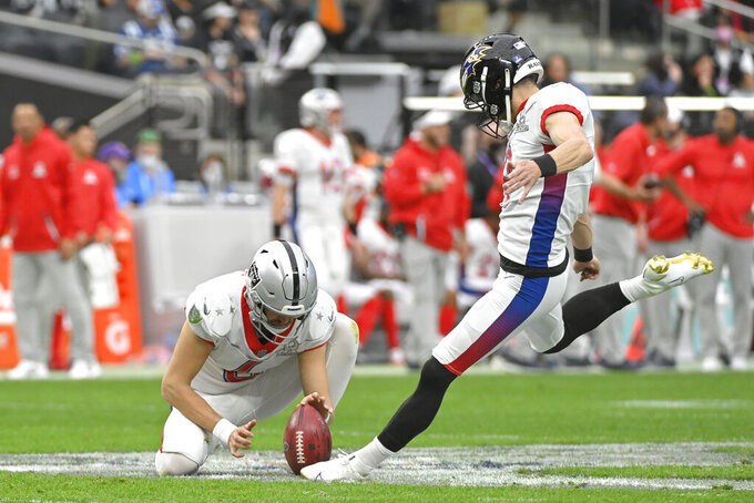FILE - AFC kicker Justin Tucker of the Baltimore Ravens, right, makes a point-after as AFC punter AJ Cole (6), of the Las Vegas Raiders, holds during the first half of the Pro Bowl NFL football game against the NFC, Sunday, Feb. 6, 2022, in Las Vegas.  The NFL is replacing the Pro Bowl with weeklong skills competitions and a flag football game. The new event will be renamed “The Pro Bowl Games” and will feature AFC and NFC players showcasing their football and non-football skills in challenges over several days.   (AP Photo/David Becker, File)