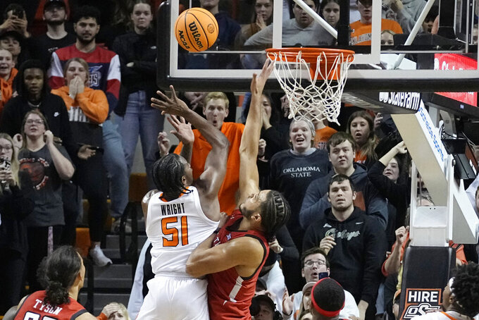 Oklahoma State guard John-Michael Wright (51) shoots the game winning basket in front of Texas Tech forward Kevin Obanor, right, in the second half of an NCAA college basketball game Wednesday, Feb. 8, 2023, in Stillwater, Okla. (AP Photo/Sue Ogrocki)