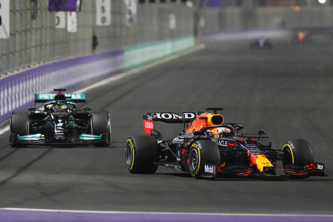 Red Bull driver Max Verstappen of the Netherlands, front, and Mercedes driver Lewis Hamilton of Britain in action t during the Formula One Saudi Arabian Grand Prix in Jiddah, Sunday, Dec. 5, 2021. (AP Photo/Hassan Ammar)