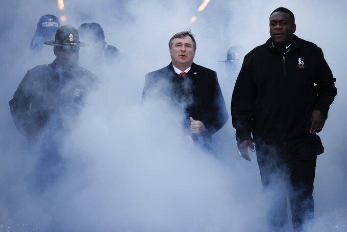 FILE - Georgia head coach Kirby Smart, center, enters the stadium during a ceremony celebrating the Bulldog's second consecutive NCAA college football national championship on Jan. 14, 2023, in Athens, Ga. The first Wednesday of February used to be the biggest day on the calendar for college football recruiting. Now it’s an afterthought. Before the championship game, Smart and TCU’s Sonny Dykes both called for changes to the crowded college football calendar without going into specifics. (AP Photo/Alex Slitz, File)