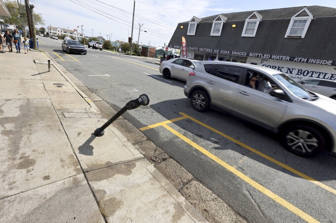 Bent parking meters are seen in front of Bagel Time Cafe in Wildwood, N.J., where an accident occurred the night before, Sunday, Sept. 25, 2022. At least two people were killed Saturday night during a pop-up car rally. (Tim Hawk/NJ Advance Media via AP)