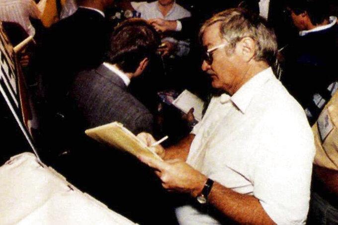 FILE - Texas sports editor, Denne Freeman listens to University of Texas Safety Stanley Richard during a news conference in Irving, Texas, just before the Cotton Bowl in 1991. Freeman, whose 32 years with the AP included covering all five Super Bowl championships won by the Dallas Cowboys and many golf majors, has died, Friday, Feb. 3, 2023 after a series of health issues. He was 86. (AP Photo/Lee Baker)