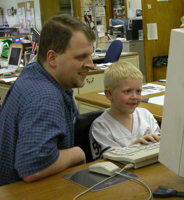 Daily Standard reporter Tim Cox watches as his son, Payton, tries to imitate his father at the office. Payton, 7, was a recent winner in the Write Now! creative writing contest at Celina East Elementary -- the same contest his father won several times as a student at Celina schools.<br>dailystandard.com