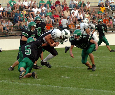 Celina defenders Jordan Heuker, 5, Erik Chapin, 10, Mike Barger, 8, and Corey Godwin, 56, gang up to tackle a Greenville ball carrier during Friday's game at Celina Stadium. Celina jumped out to a big lead and went on to knock off Greenville for the 12th straight time, 41-27.<br>dailystandard.com