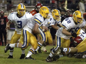 St. Marys running back Bo Frye, with ball, follows his blocking en route to a big gainer during Friday's Western Buckeye League showdown against Shawnee in a battle for first place in the league. Frye ran for a game-high 99 yards, but Shawnee defeated St. Marys 7-6, the first Indians win over the Roughriders since 1986.<br>dailystandard.com