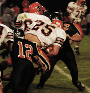Coldwater's Ross Homan, 25, is brought down on the play by Minter's Aaron Heitbrink, 12, and Andrew Meyer, 40, during their game on Friday night. Coldwater won, 27-21.<br>dailystandard.com